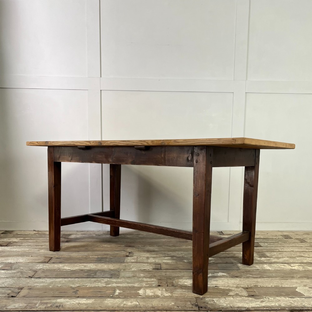 A 19th-century Welsh pine kitchen table featuring a light wood plank top supported by a dark stained wooden frame with square legs and a low stretcher. View II