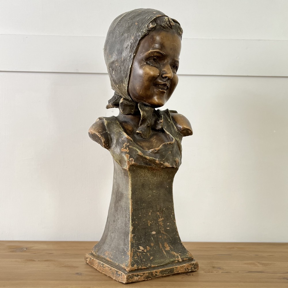 A pair of early 20th-century terracotta busts depicting a young boy and girl with aged bronze-effect finishes on integrated square pedestals. View XIII