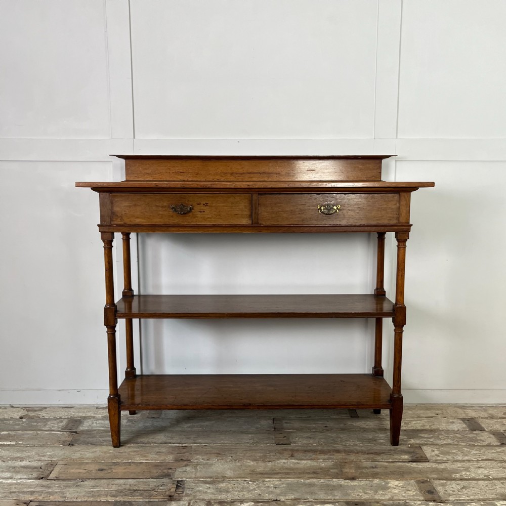 A pair of Victorian oak serving tables featuring tiered shelves, turned upright supports, and two frieze drawers with brass handles. View II