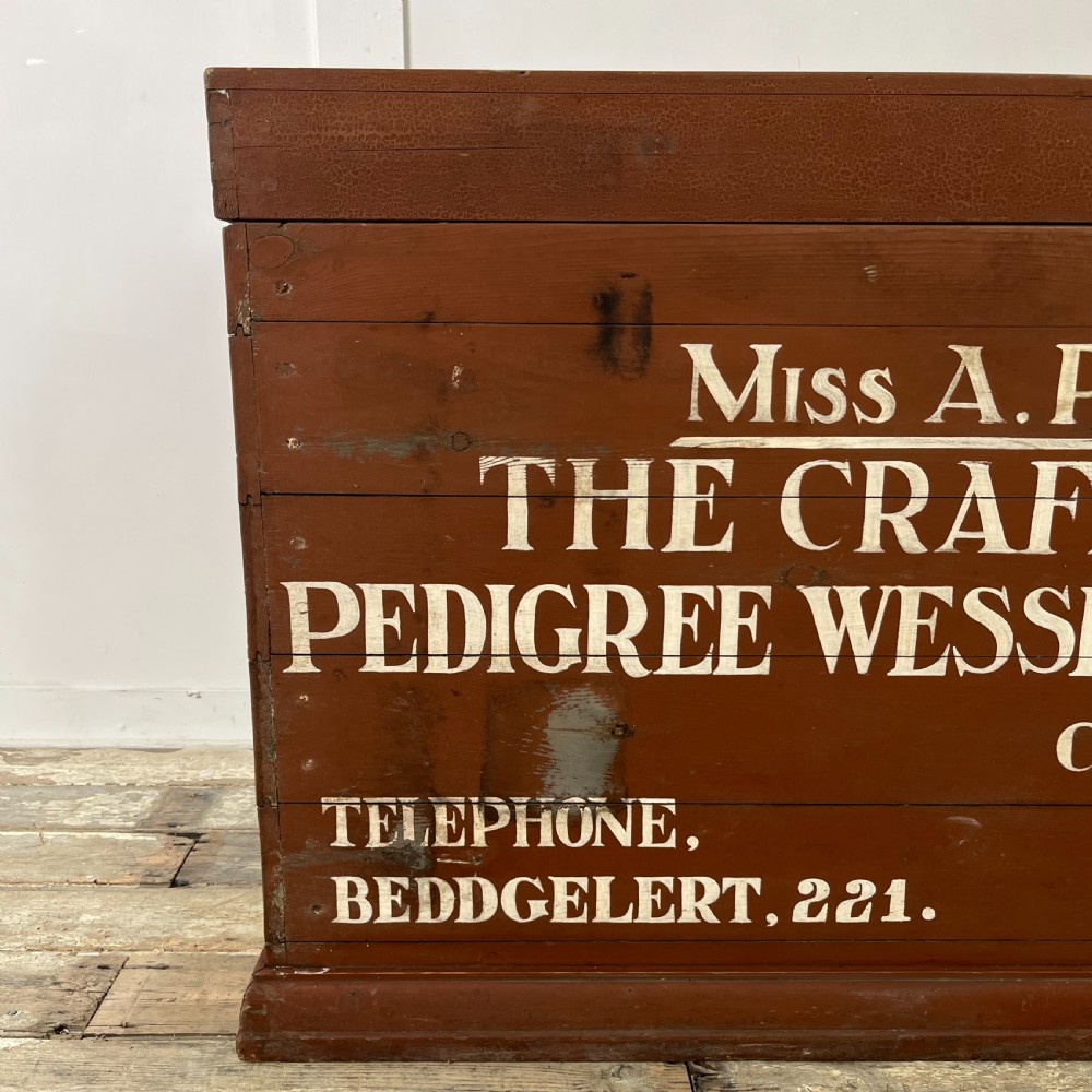 A rectangular reddish-brown painted pine storage chest featuring white hand-painted agricultural typography on the front panel. View VII