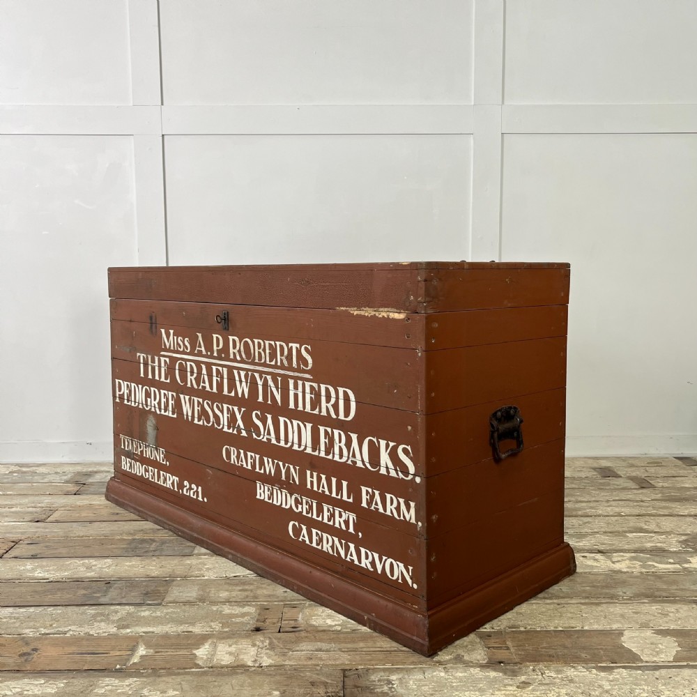 A rectangular reddish-brown painted pine storage chest featuring white hand-painted agricultural typography on the front panel. View VIII