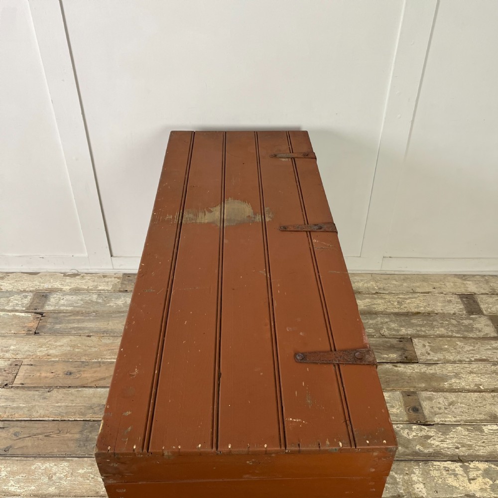 A rectangular reddish-brown painted pine storage chest featuring white hand-painted agricultural typography on the front panel. View IX