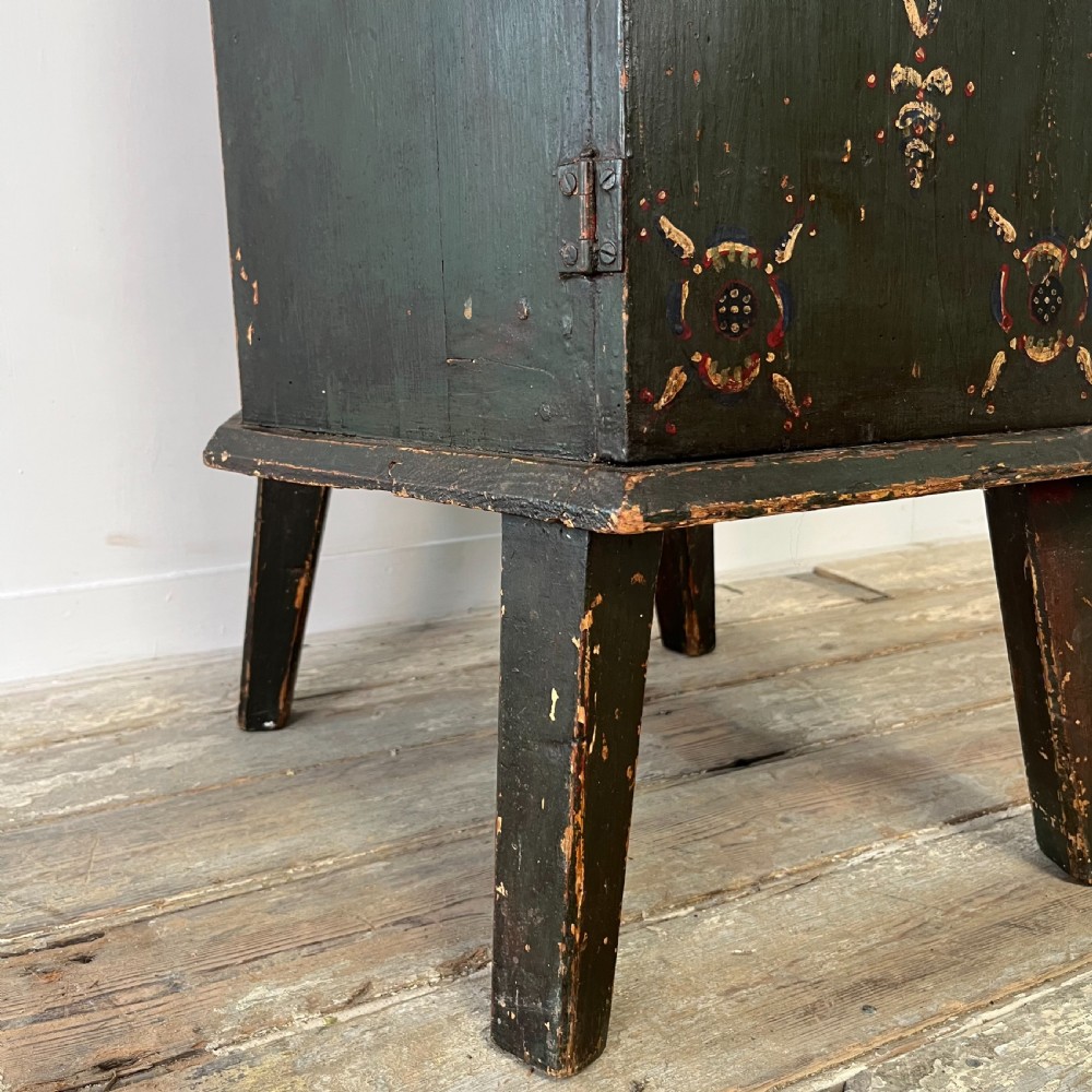 A 19th-century European folk art childs high chair featuring a dark painted enclosed cupboard base and a crimson shaped backrest decorated with hand-painted floral motifs. View XV