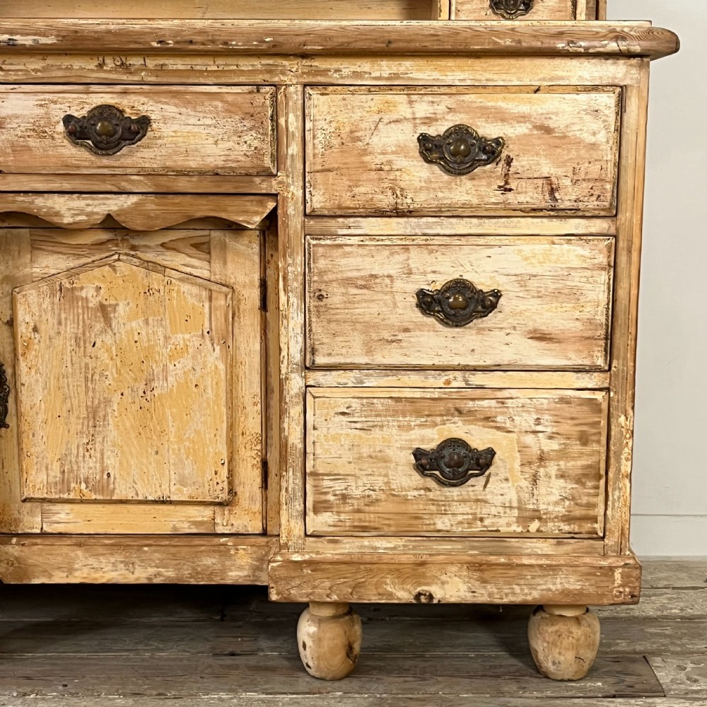 Victorian painted pine dresser with a shaped architectural backboard, multiple drawers, central cupboard, and bun feet in a distressed finish. View VI