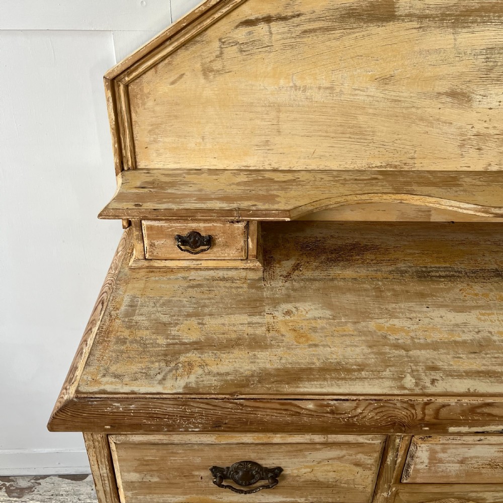 Victorian painted pine dresser with a shaped architectural backboard, multiple drawers, central cupboard, and bun feet in a distressed finish. View VII