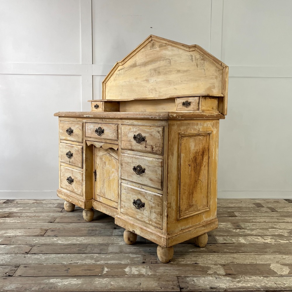Victorian painted pine dresser with a shaped architectural backboard, multiple drawers, central cupboard, and bun feet in a distressed finish. View IX
