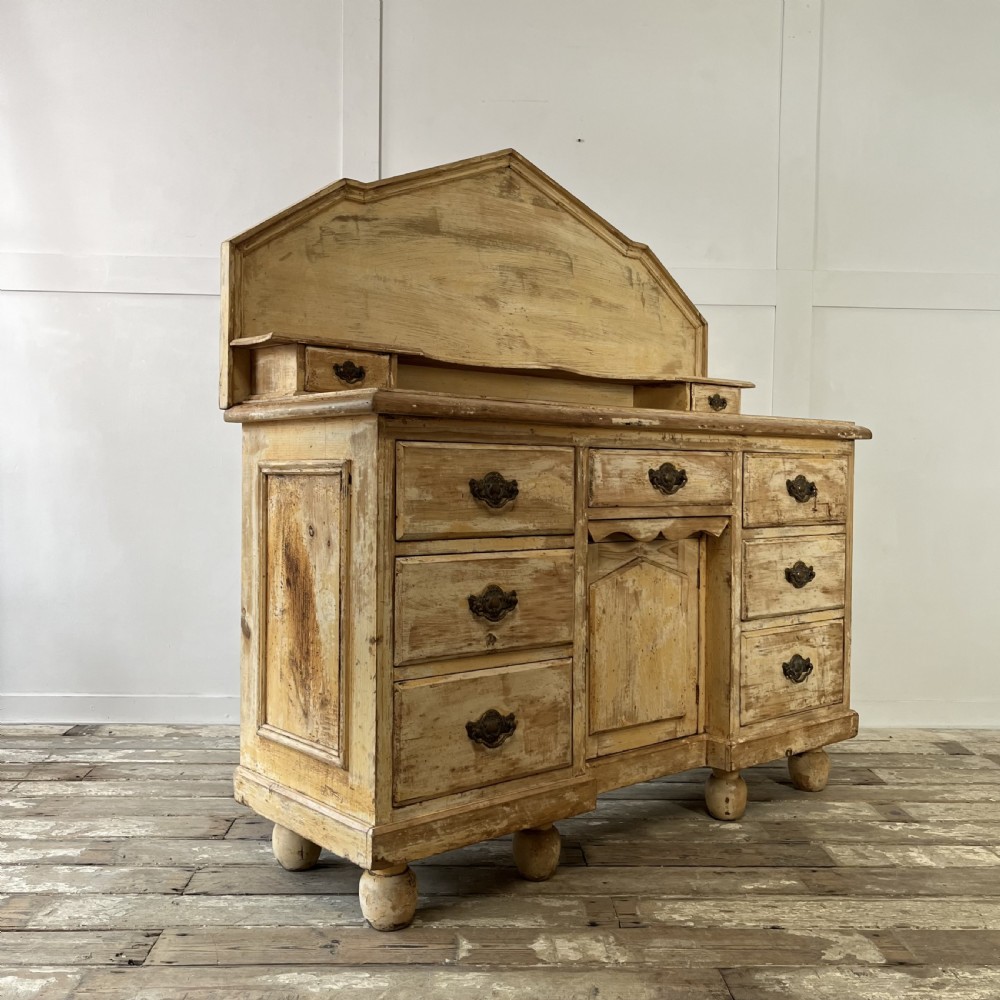 Victorian painted pine dresser with a shaped architectural backboard, multiple drawers, central cupboard, and bun feet in a distressed finish. View XIII
