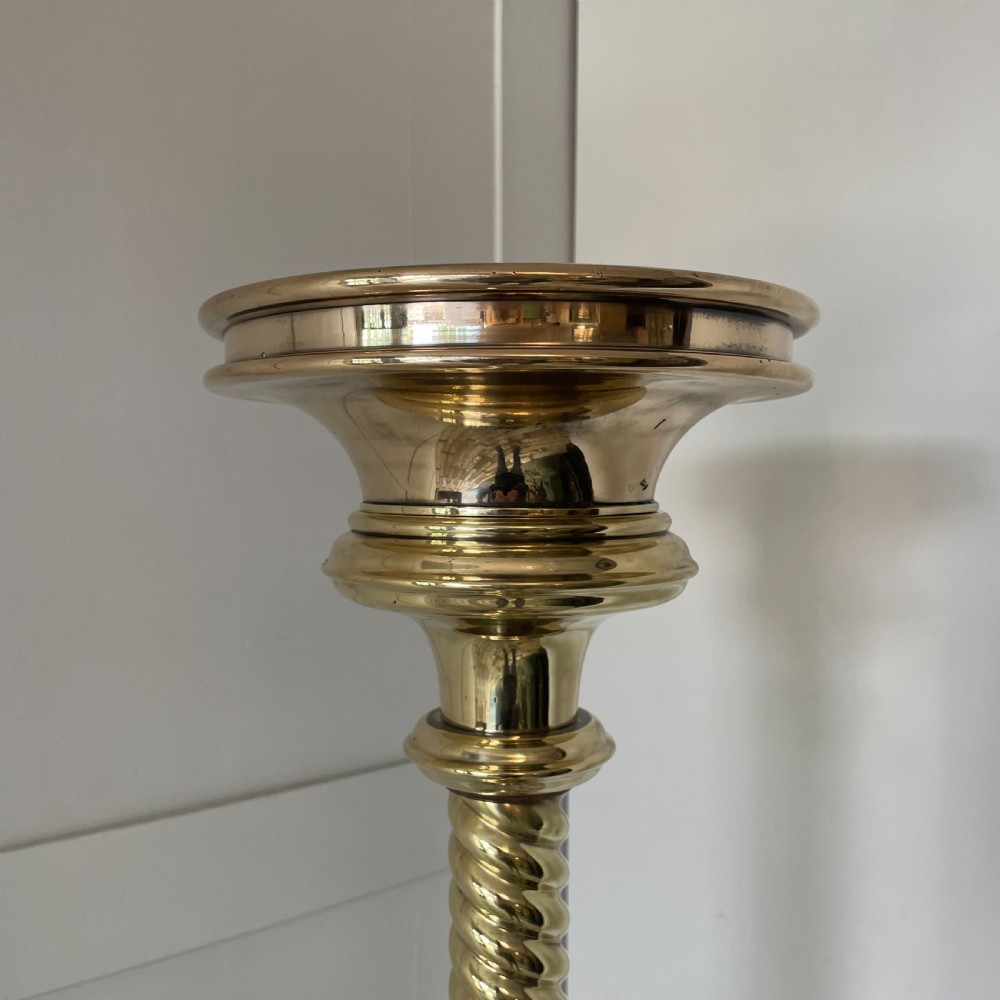 A tall 19th-century Gothic Revival floor-standing church candlestick with a spiral-twist brass column and a dark metal flared base. View II