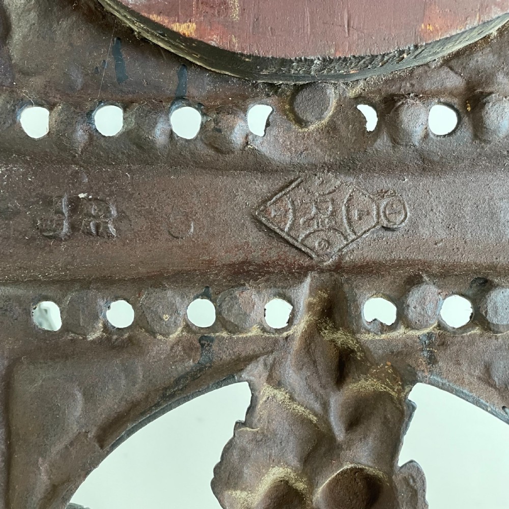 A tall black cast iron Victorian hall stand featuring an integrated central mirror, branching coat hooks, scrollwork tracery, and an umbrella drip tray at the base. View XIX
