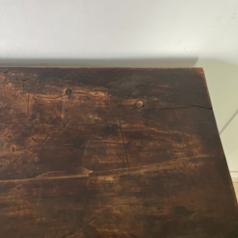 An early nineteenth-century Spanish dark walnut console table featuring carved panel drawers, turned legs, and an H-stretcher. View X