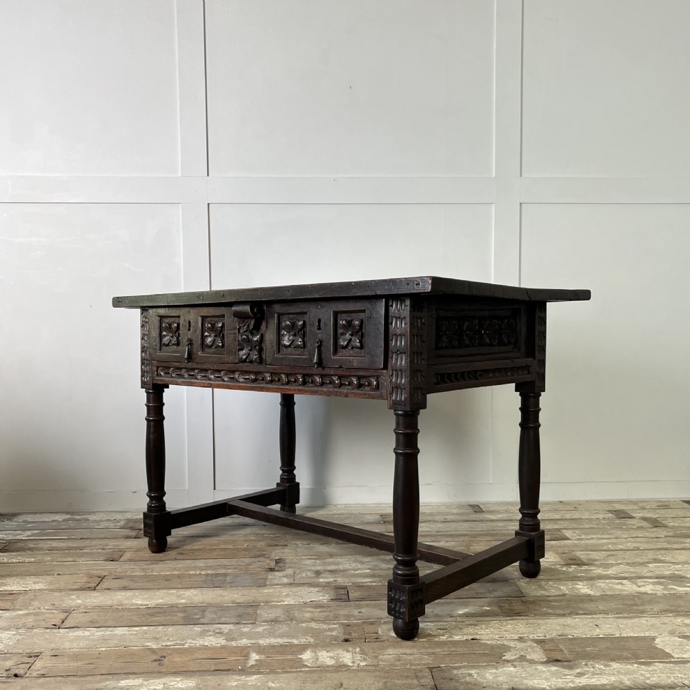 An early nineteenth-century Spanish dark walnut console table featuring carved panel drawers, turned legs, and an H-stretcher. View XI