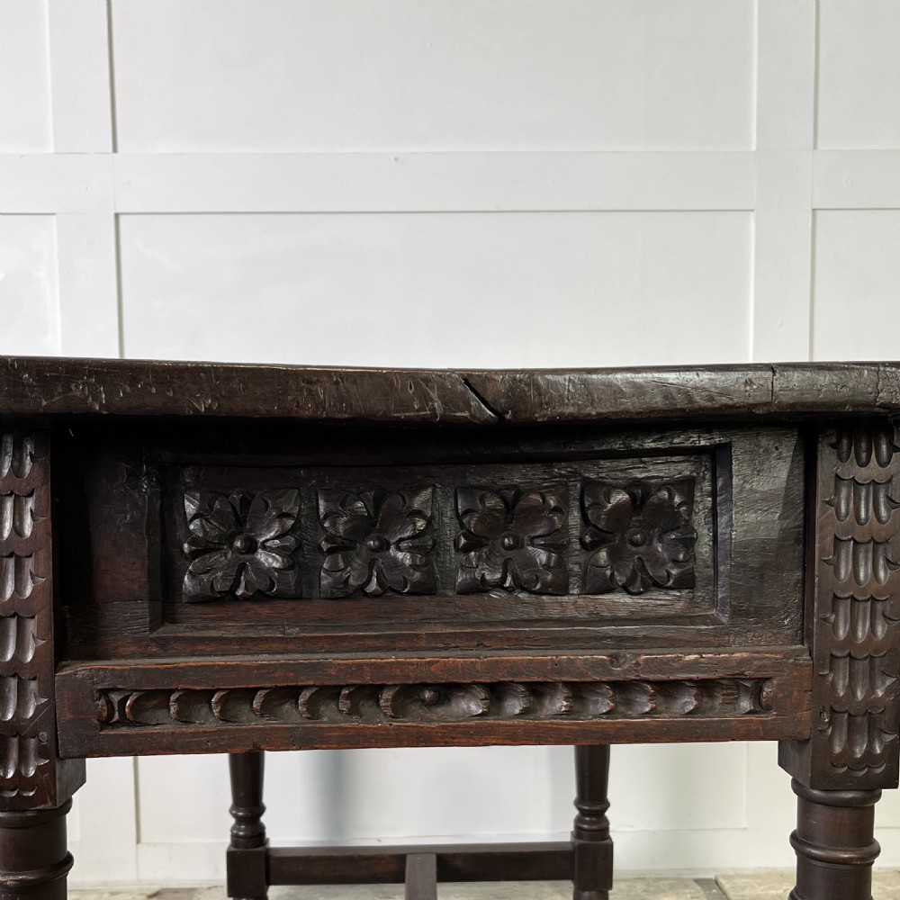 An early nineteenth-century Spanish dark walnut console table featuring carved panel drawers, turned legs, and an H-stretcher. View XII