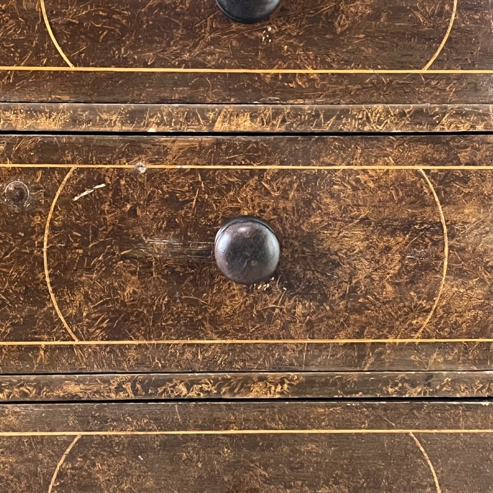 A nineteenth-century scumble-painted pine chest of drawers with decorative faux inlay lines, dark turned handles, and ball feet. View IV
