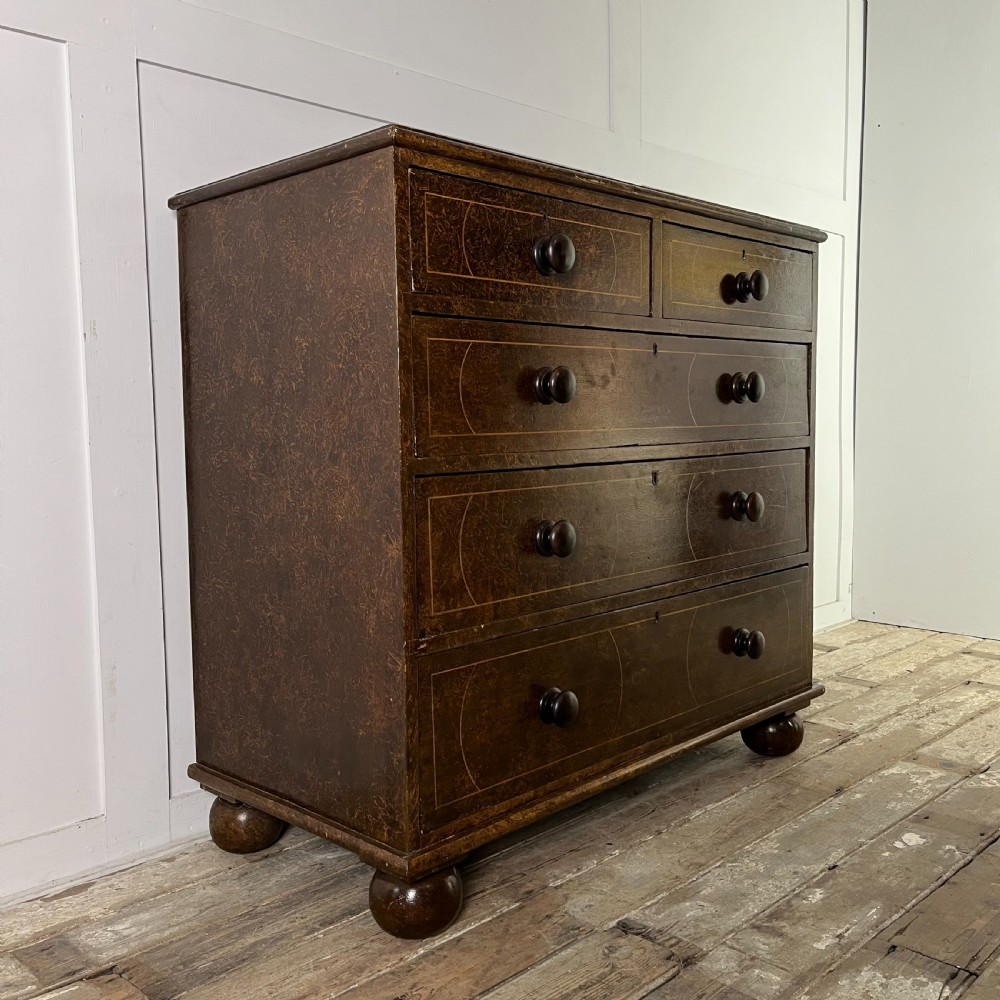 A nineteenth-century scumble-painted pine chest of drawers with decorative faux inlay lines, dark turned handles, and ball feet. View VII