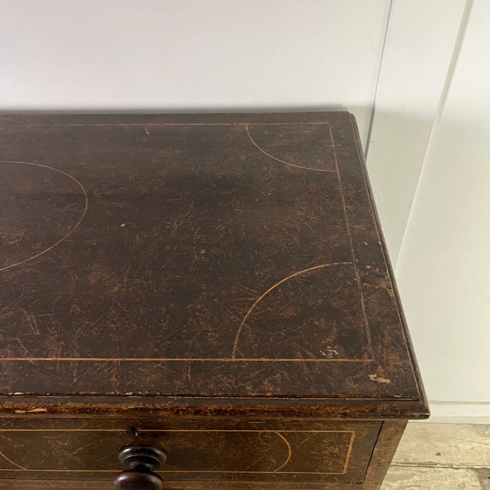A nineteenth-century scumble-painted pine chest of drawers with decorative faux inlay lines, dark turned handles, and ball feet. View XI