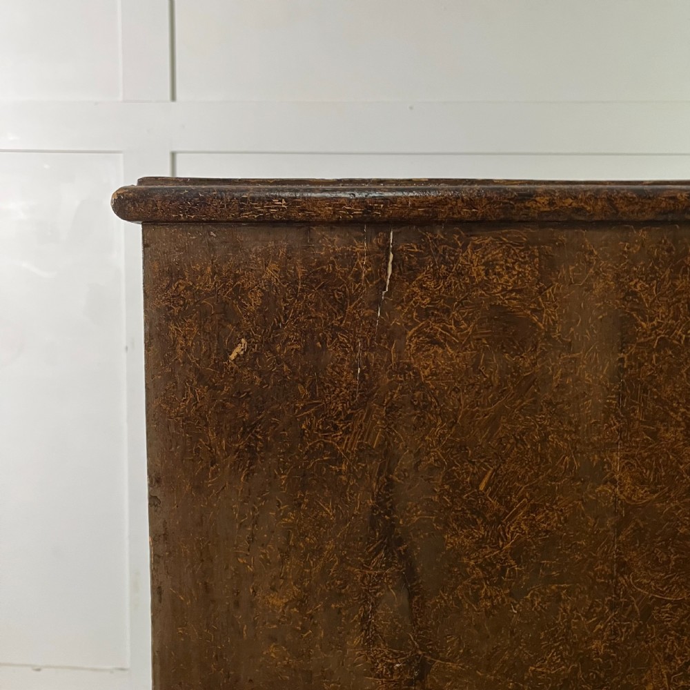 A nineteenth-century scumble-painted pine chest of drawers with decorative faux inlay lines, dark turned handles, and ball feet. View XVII