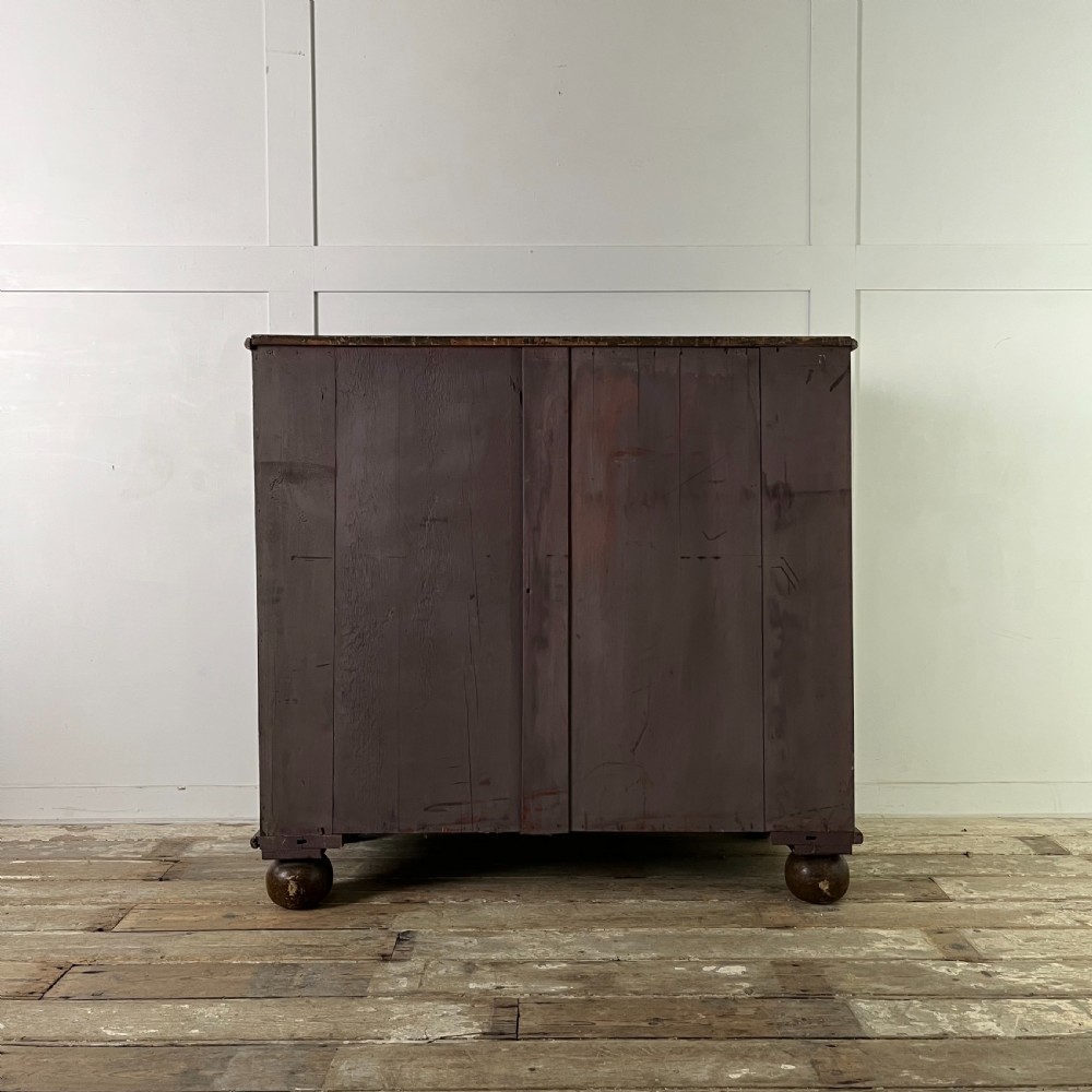 A nineteenth-century scumble-painted pine chest of drawers with decorative faux inlay lines, dark turned handles, and ball feet. View XVIII