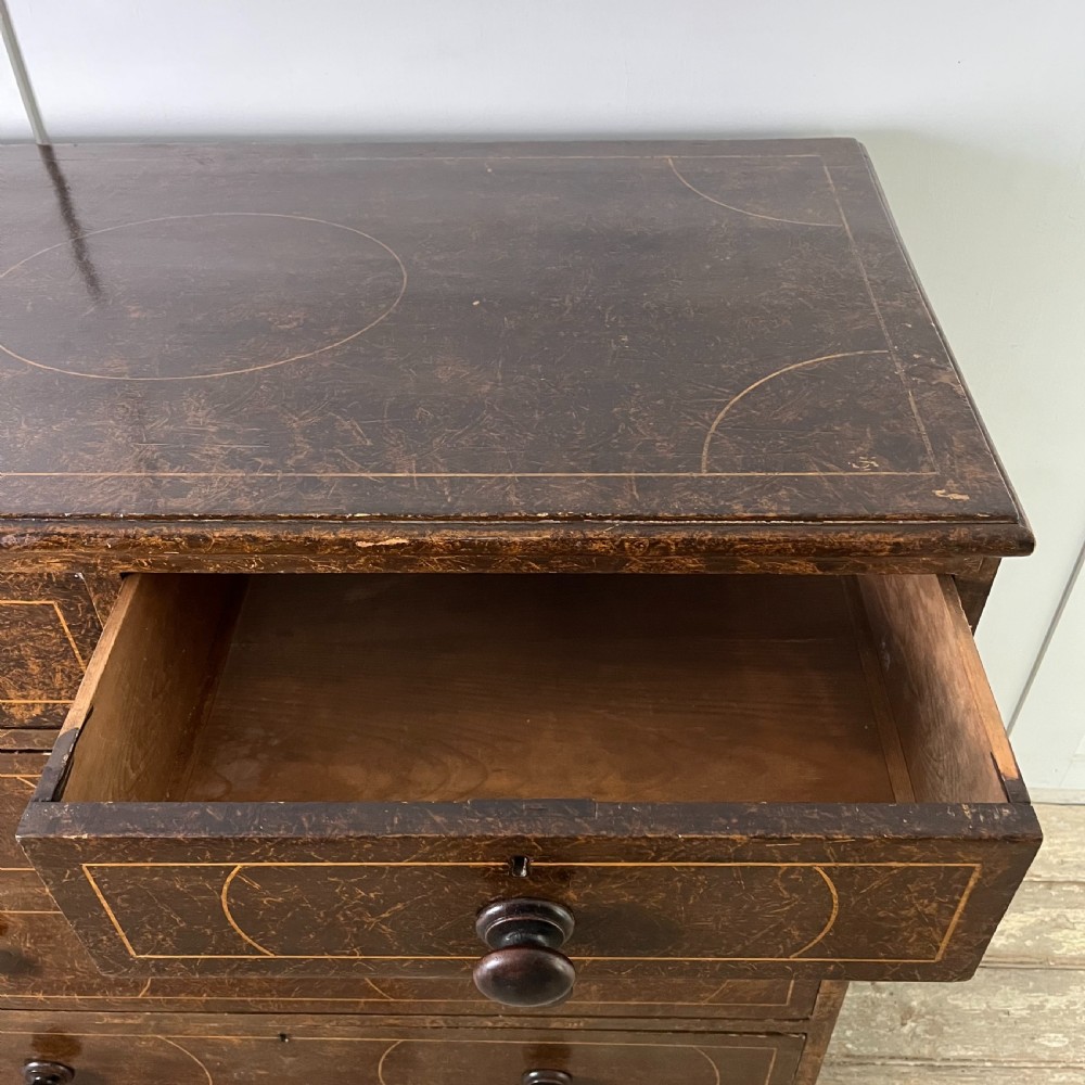 A nineteenth-century scumble-painted pine chest of drawers with decorative faux inlay lines, dark turned handles, and ball feet. View XXII