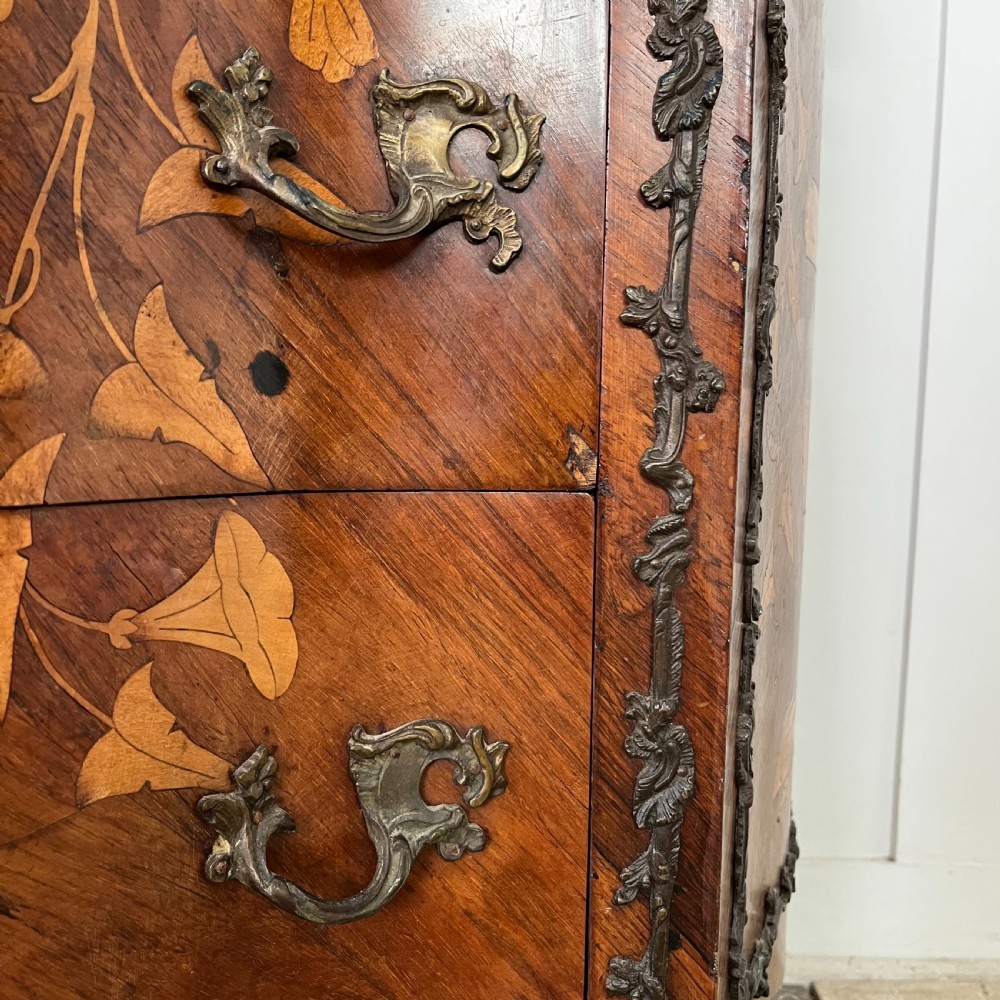 A nineteenth-century French rosewood commode featuring intricate floral marquetry, gilt-bronze mounts, three drawers, and a shaped marble top. View V