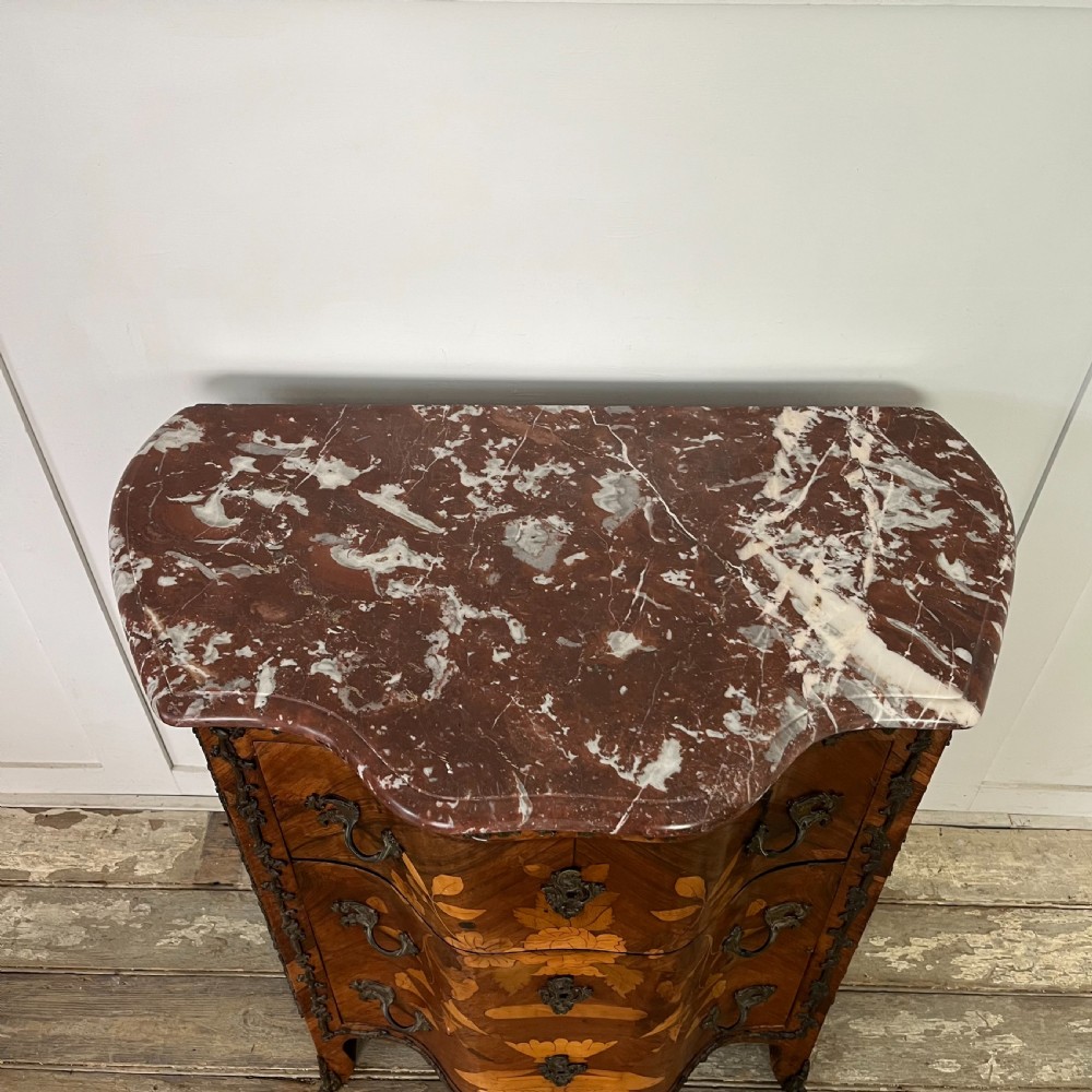 A nineteenth-century French rosewood commode featuring intricate floral marquetry, gilt-bronze mounts, three drawers, and a shaped marble top. View IX