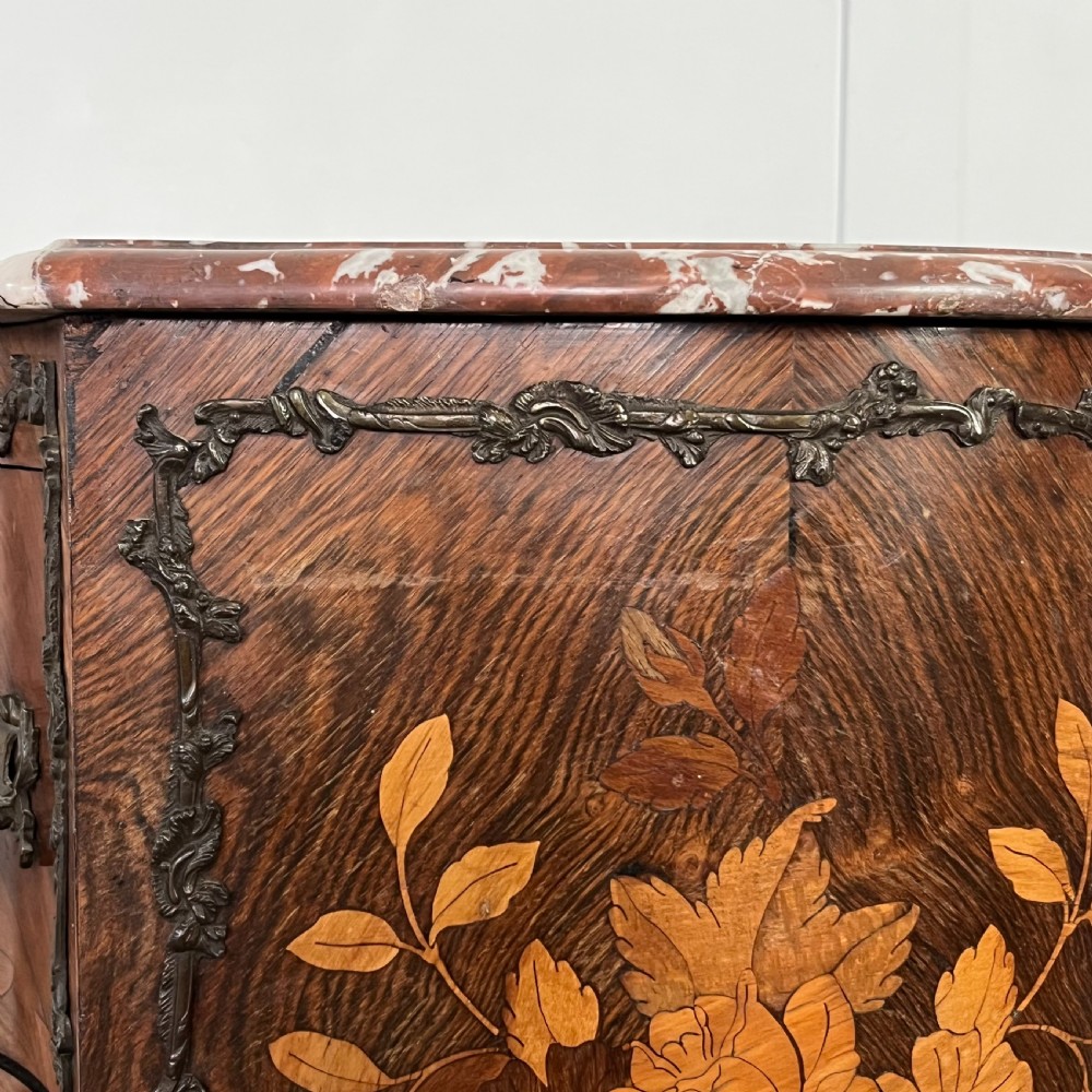 A nineteenth-century French rosewood commode featuring intricate floral marquetry, gilt-bronze mounts, three drawers, and a shaped marble top. View XIII
