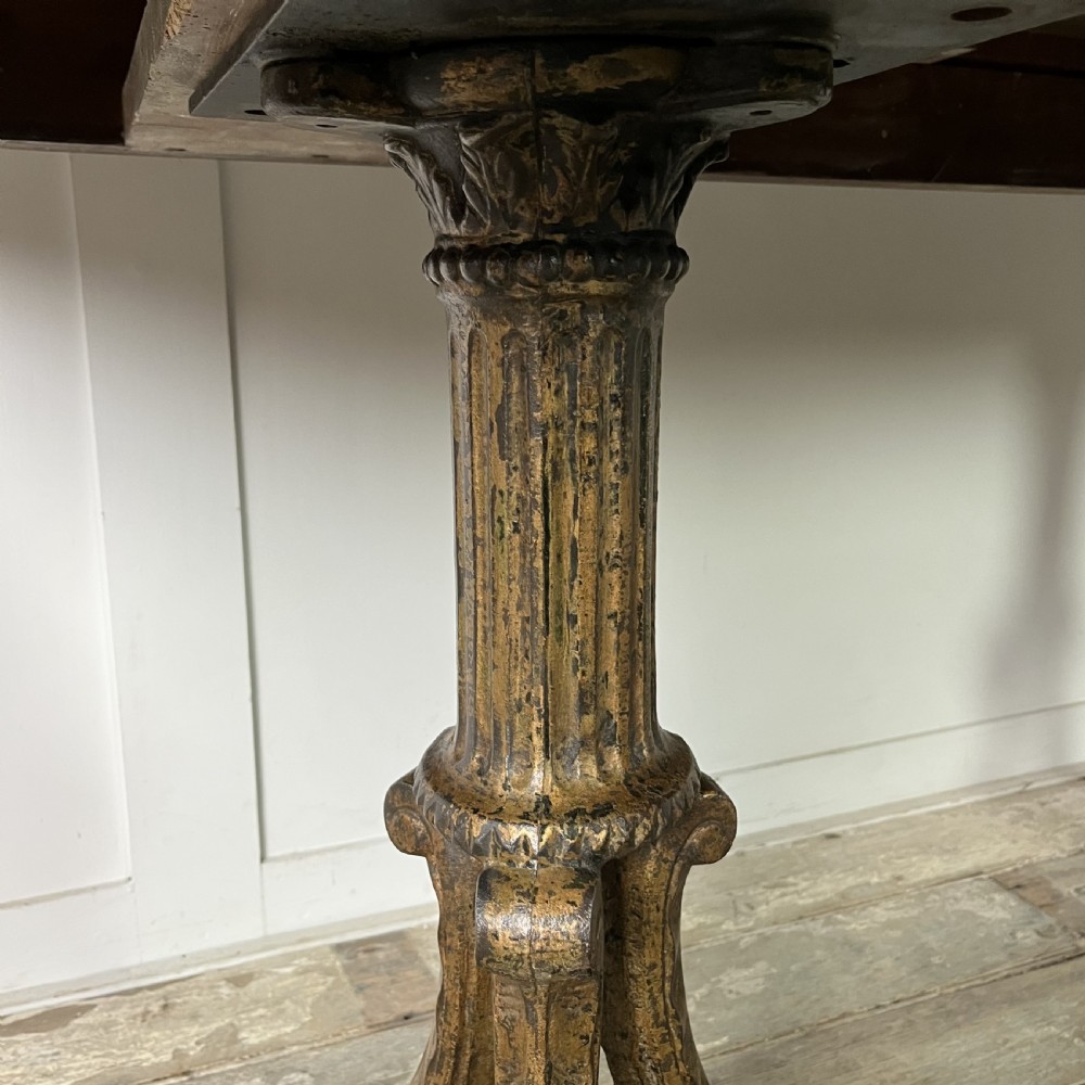 A long rectangular Victorian oak table featuring a thick wooden top resting on two ornate cast-iron pedestal legs. View IV
