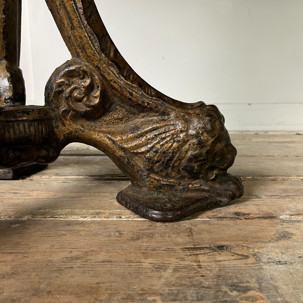 A long rectangular Victorian oak table featuring a thick wooden top resting on two ornate cast-iron pedestal legs. View V