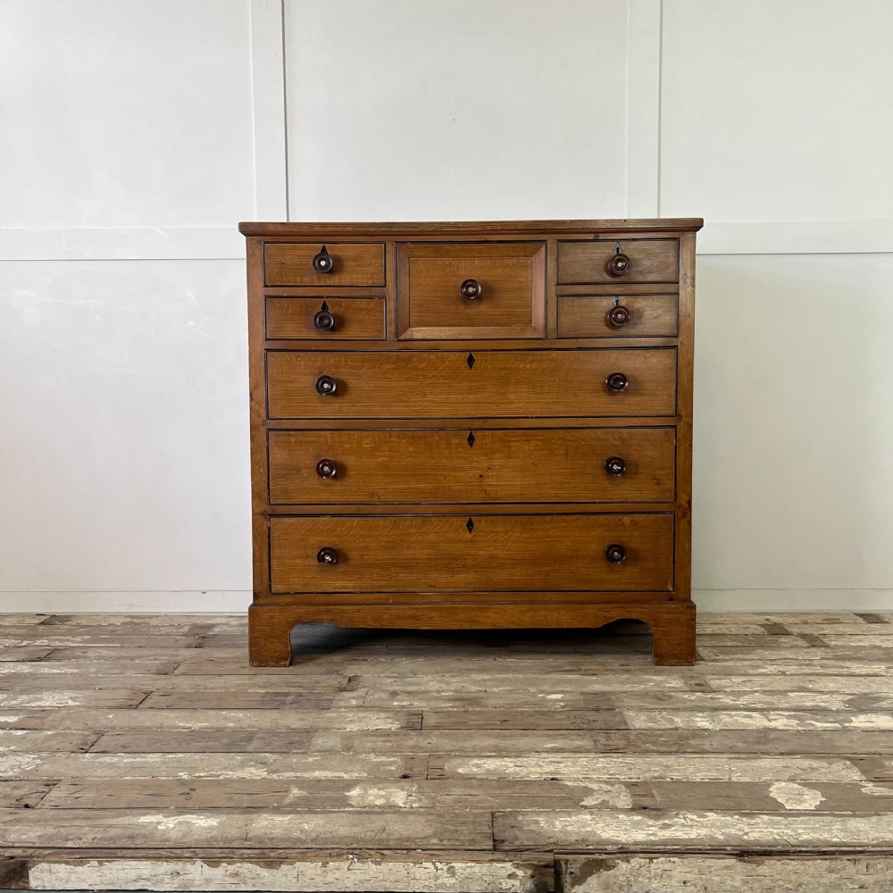 A large Victorian scumble painted pine chest of drawers featuring five graduated drawers and turned wooden knobs.