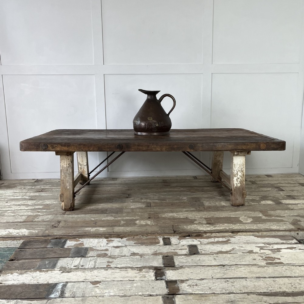 An early 20th-century rustic cheese press table featuring a thick dark wooden top and distressed painted trestle legs with metal bracing. View II