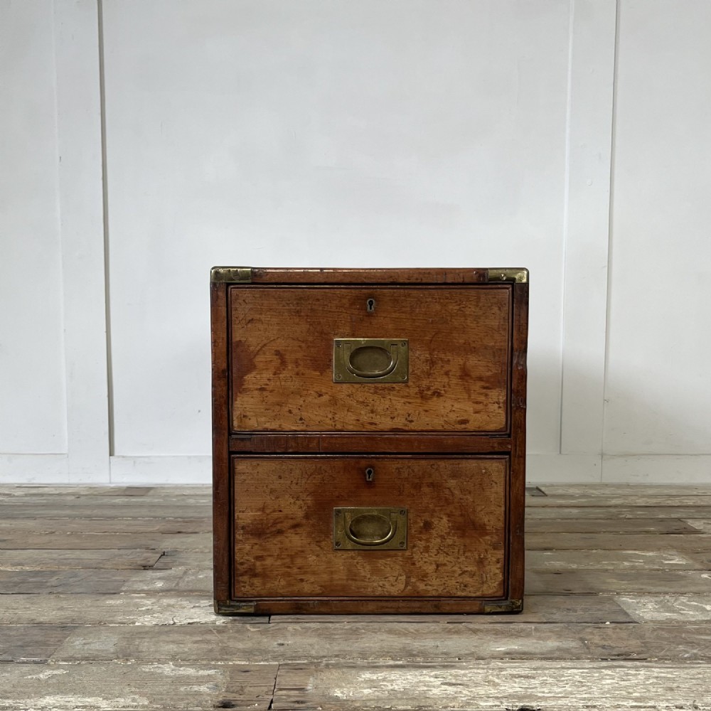 A nineteenth-century rectangular wooden desktop campaign chest featuring two drawers, flush brass drop handles, and brass corner straps. View V