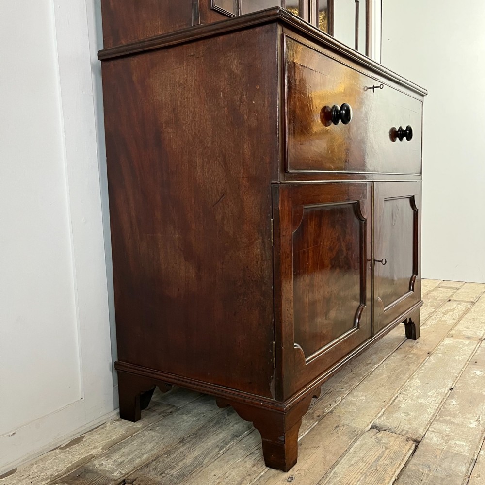 A dark mahogany George III secretaire bookcase featuring upper astragal glazed doors, a fold-out secretaire desk section with green leather insert, and lower cupboard doors on bracket feet. View VIII