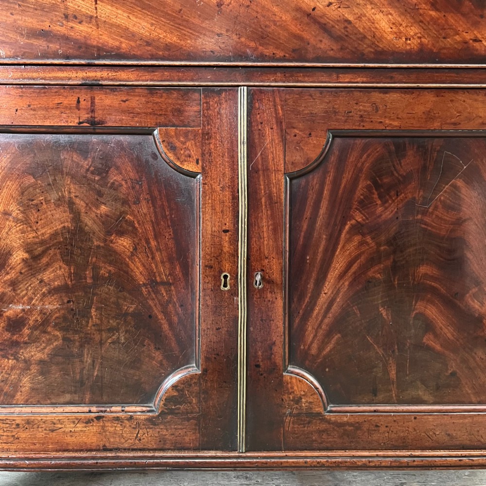 A dark mahogany George III secretaire bookcase featuring upper astragal glazed doors, a fold-out secretaire desk section with green leather insert, and lower cupboard doors on bracket feet. View XII