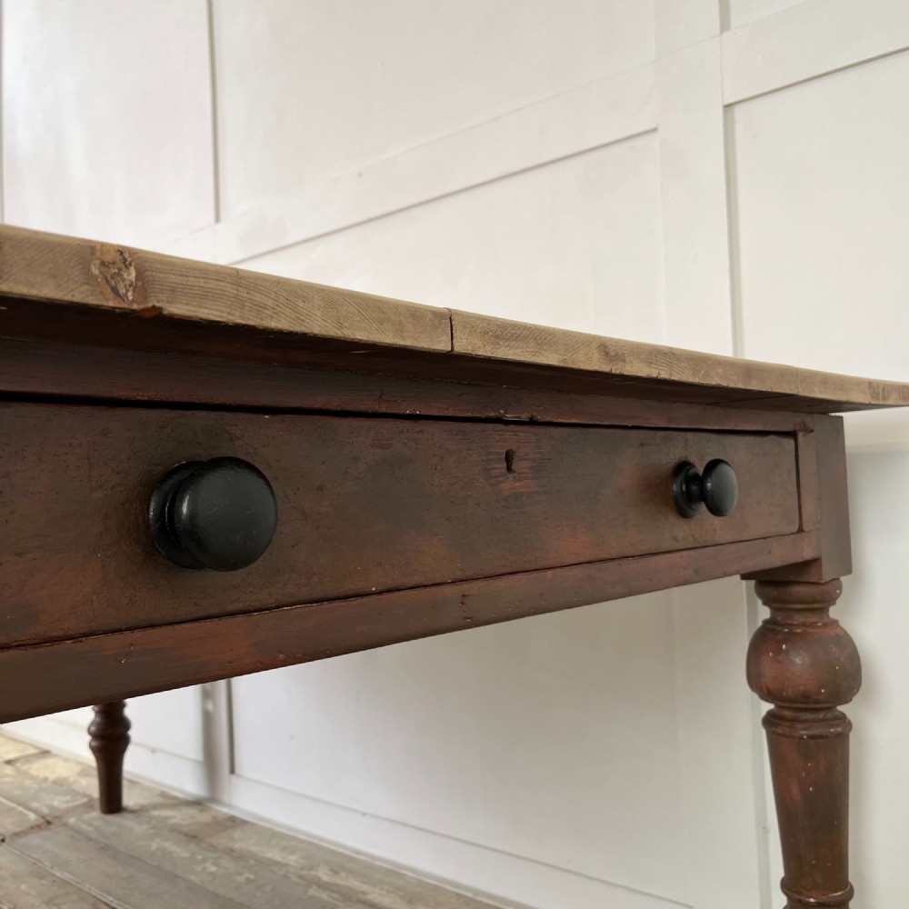 A large Victorian pine farmhouse table featuring a light natural wood plank top supported by dark brown turned wooden legs. View X