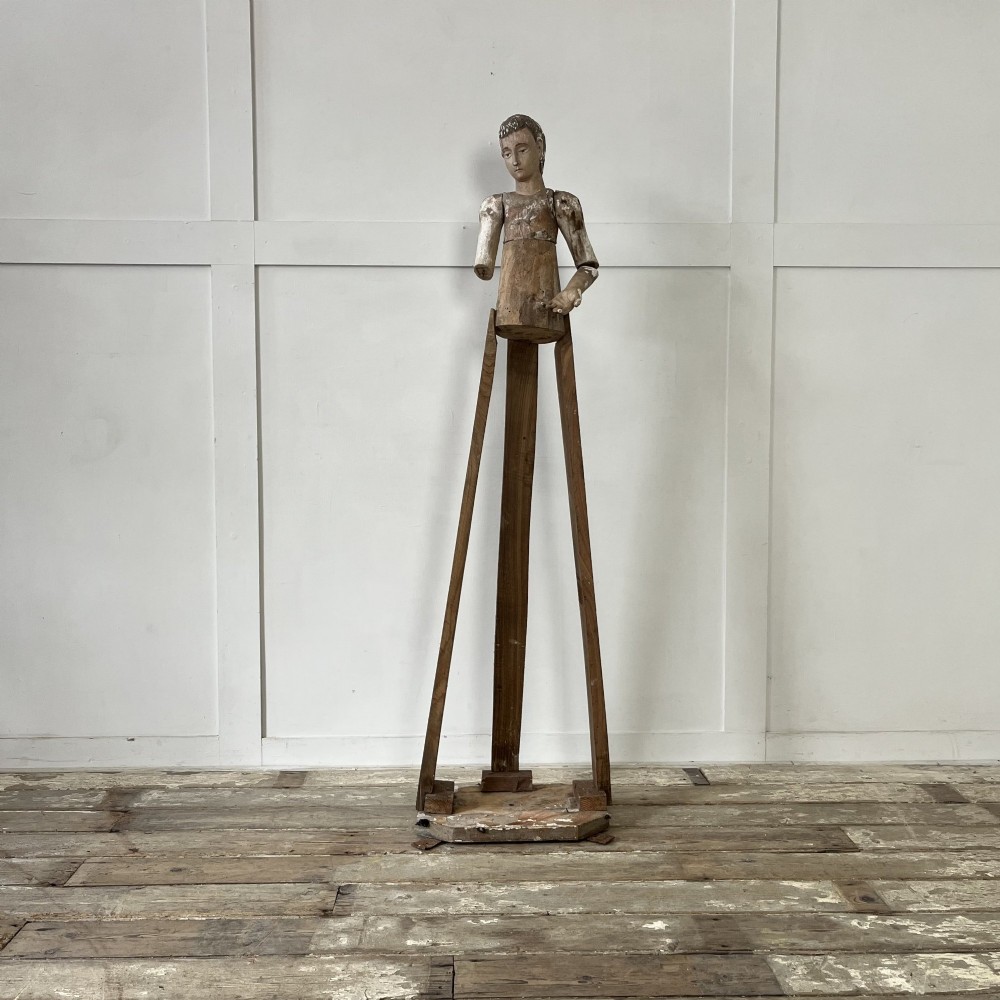An 18th-century Spanish capipote featuring a carved wooden polychrome head and torso mounted on a tall wooden tripod cage frame.