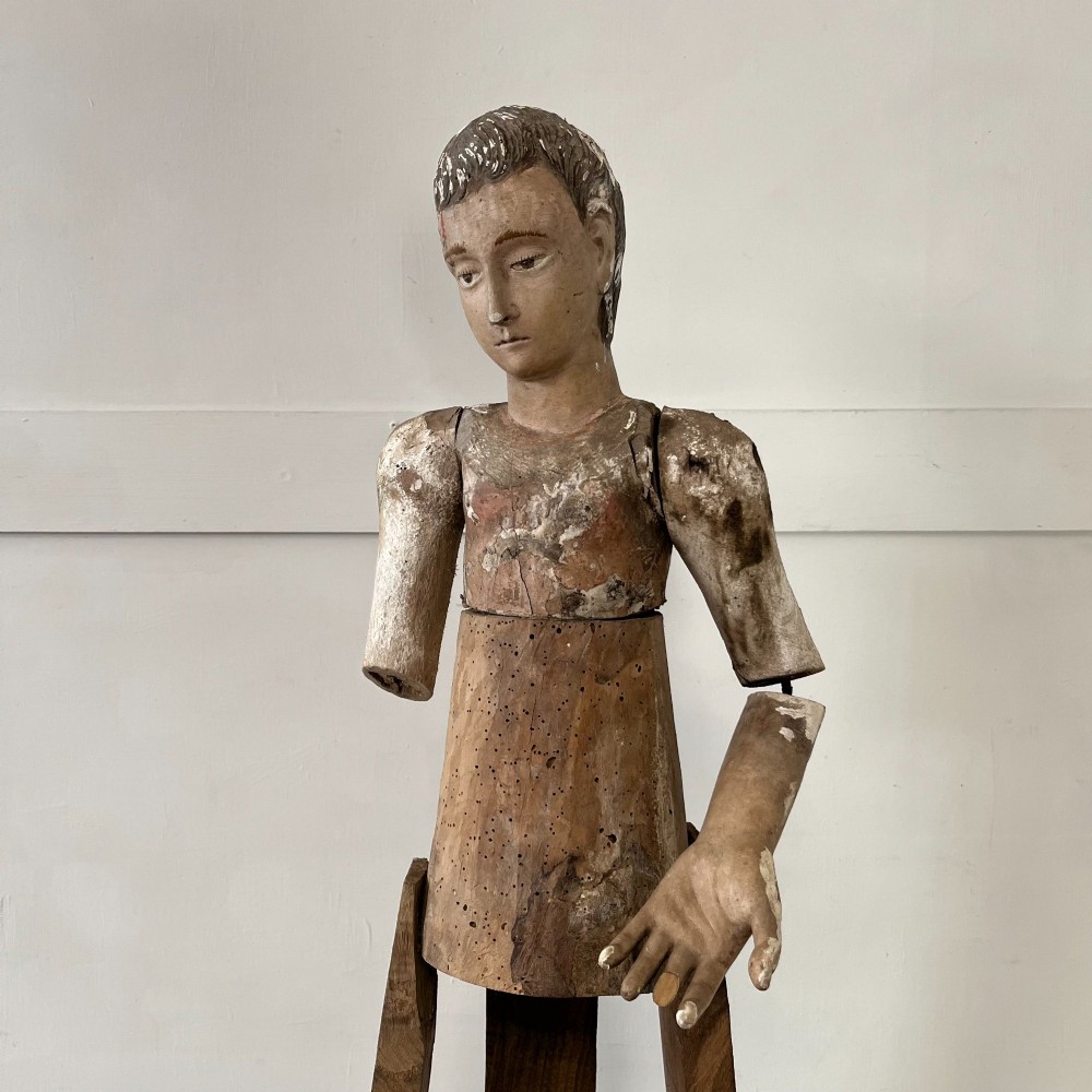 An 18th-century Spanish capipote featuring a carved wooden polychrome head and torso mounted on a tall wooden tripod cage frame. View II