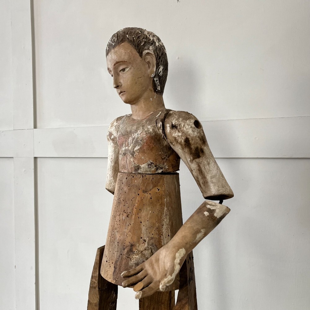 An 18th-century Spanish capipote featuring a carved wooden polychrome head and torso mounted on a tall wooden tripod cage frame. View V