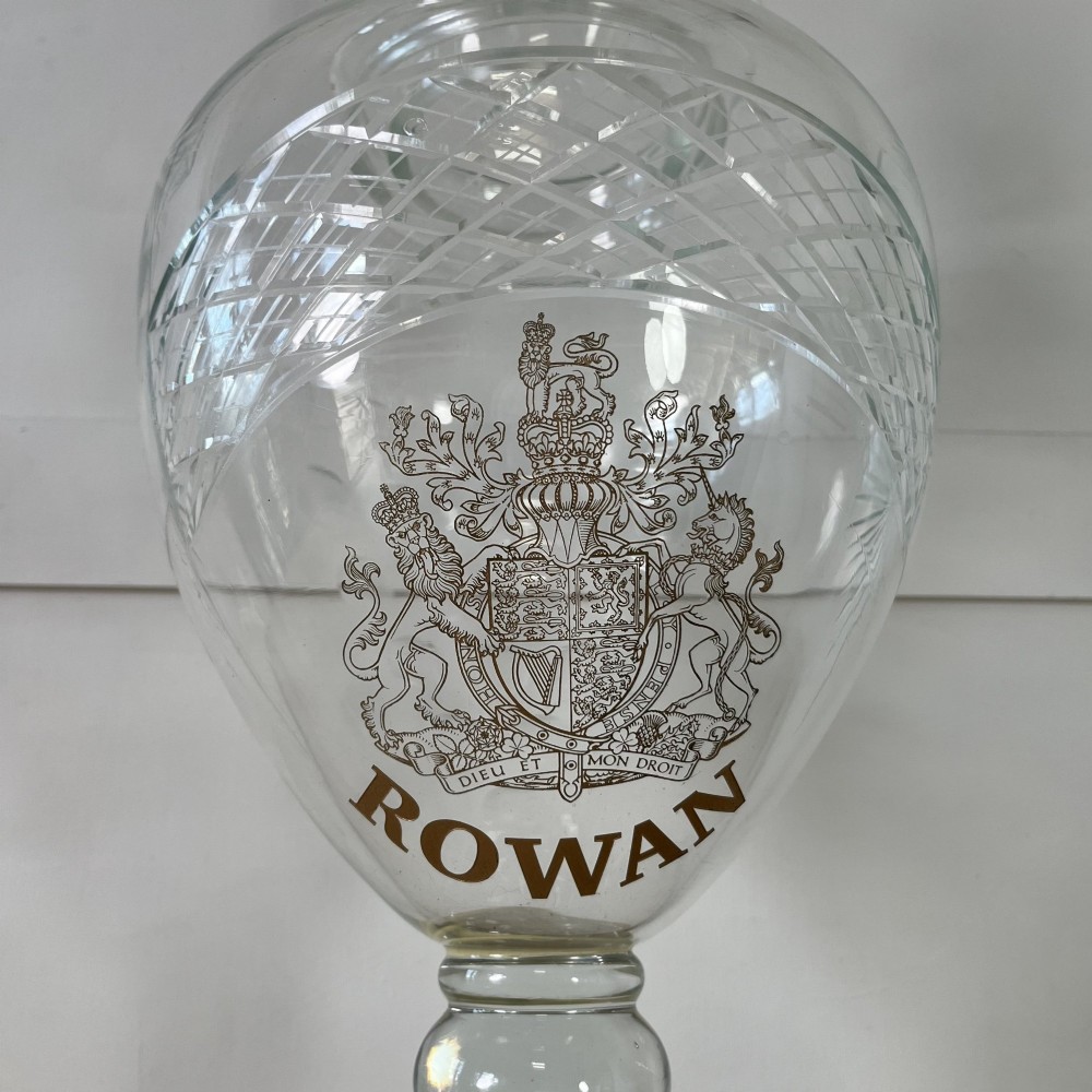 A clear cut glass Edwardian apothecary jar with a pointed finial lid, lattice shoulder pattern, and printed crest above the text ROWAN. View III