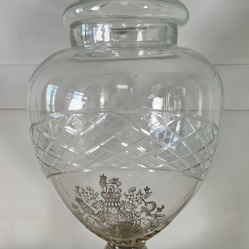 A clear cut glass Edwardian apothecary jar with a pointed finial lid, lattice shoulder pattern, and printed crest above the text ROWAN. View IV