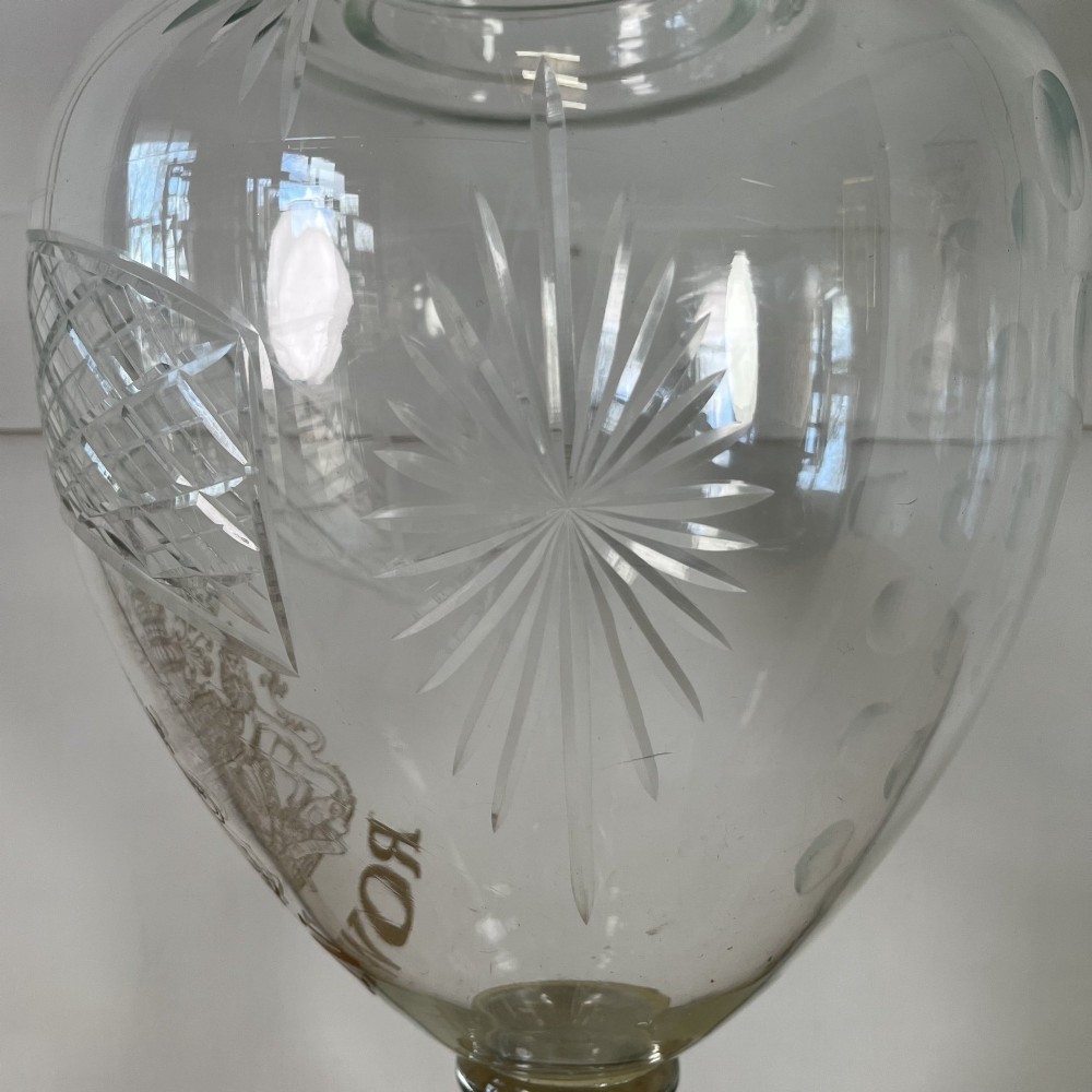 A clear cut glass Edwardian apothecary jar with a pointed finial lid, lattice shoulder pattern, and printed crest above the text ROWAN. View VI