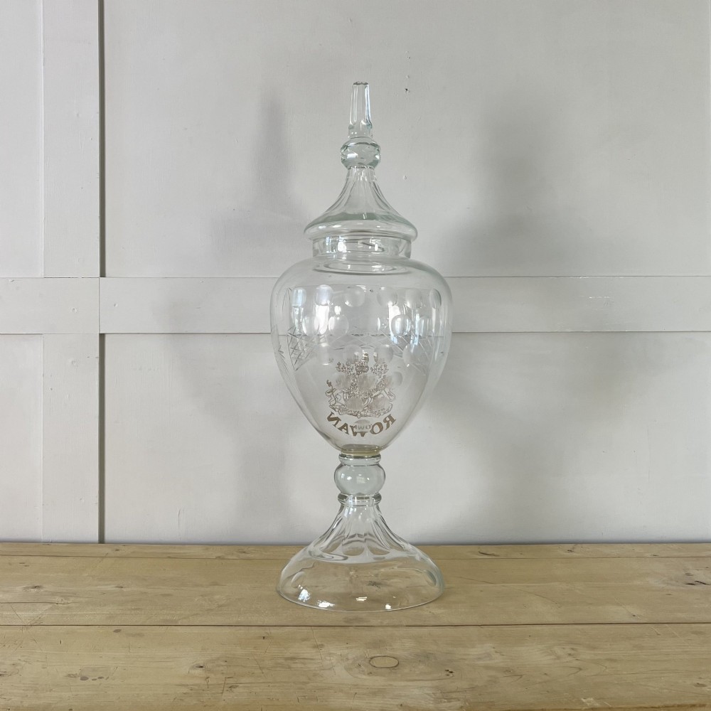A clear cut glass Edwardian apothecary jar with a pointed finial lid, lattice shoulder pattern, and printed crest above the text ROWAN. View IX