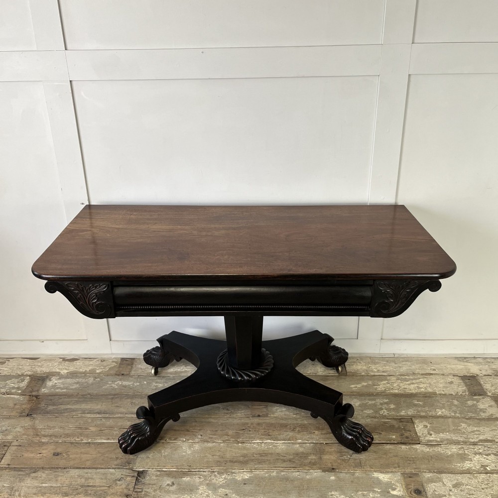 A pair of William IV ebonised mahogany console tables with polished mahogany tops, central pedestal columns, and carved claw feet on brass castors. View IV