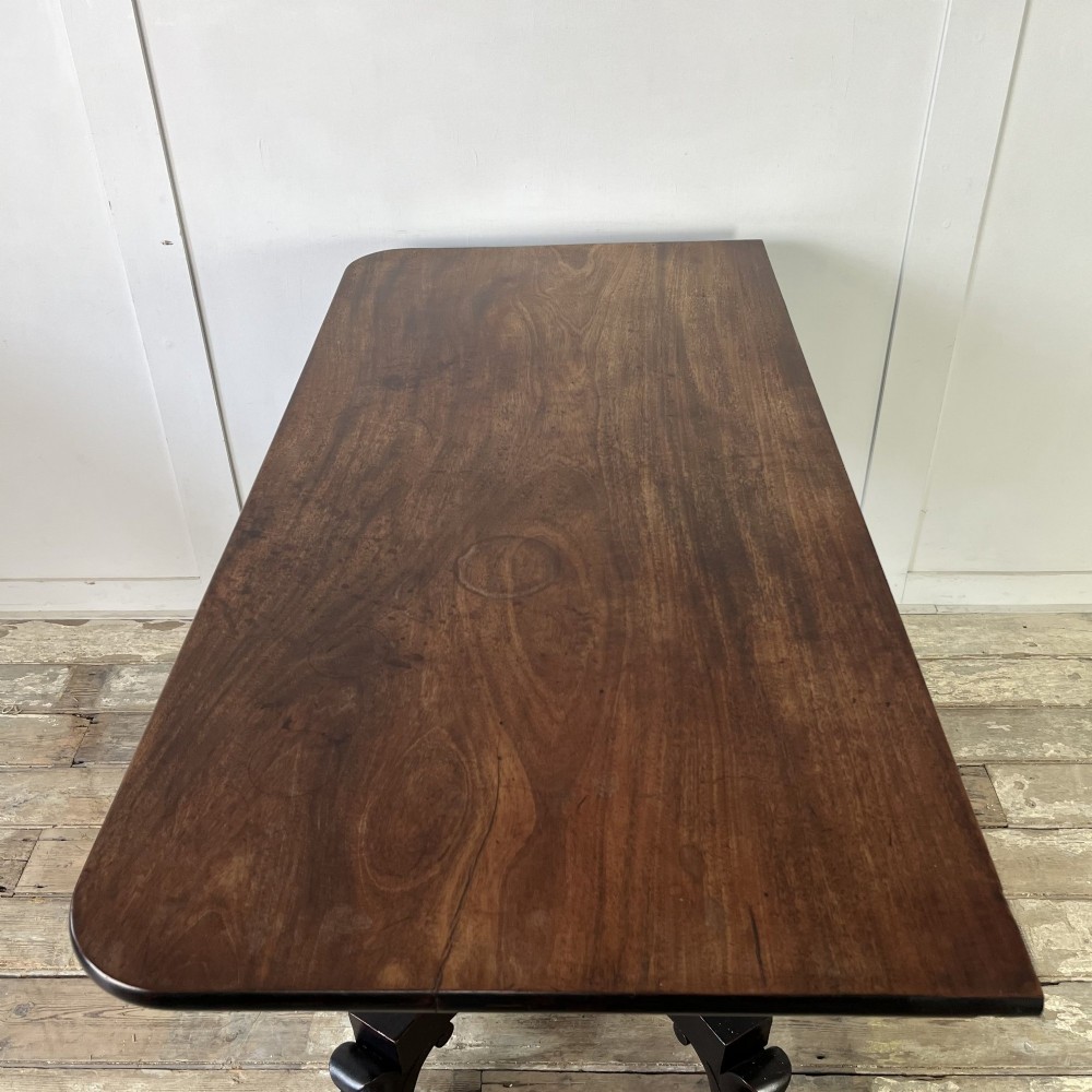 A pair of William IV ebonised mahogany console tables with polished mahogany tops, central pedestal columns, and carved claw feet on brass castors. View V