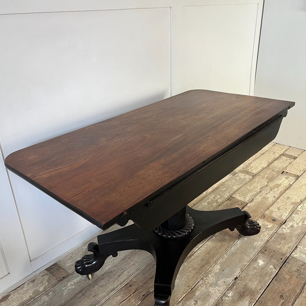 A pair of William IV ebonised mahogany console tables with polished mahogany tops, central pedestal columns, and carved claw feet on brass castors. View VI