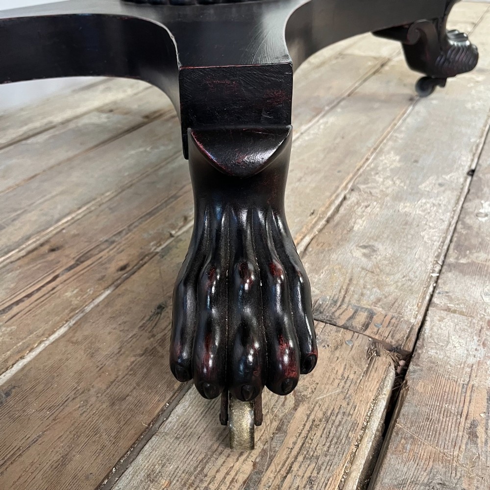 A pair of William IV ebonised mahogany console tables with polished mahogany tops, central pedestal columns, and carved claw feet on brass castors. View VIII