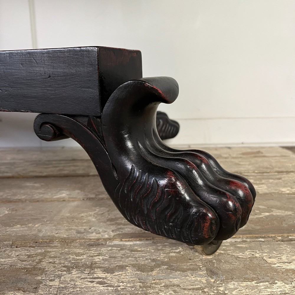 A pair of William IV ebonised mahogany console tables with polished mahogany tops, central pedestal columns, and carved claw feet on brass castors. View IX