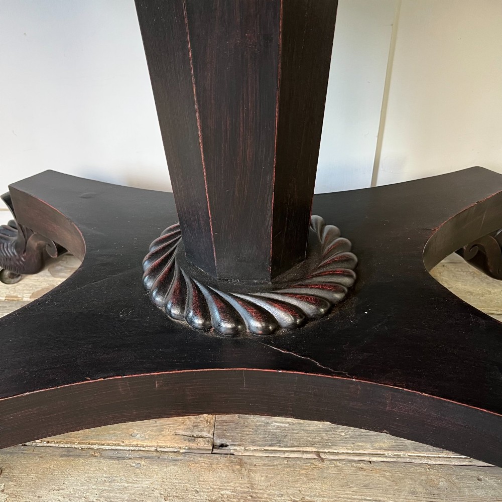 A pair of William IV ebonised mahogany console tables with polished mahogany tops, central pedestal columns, and carved claw feet on brass castors. View XII