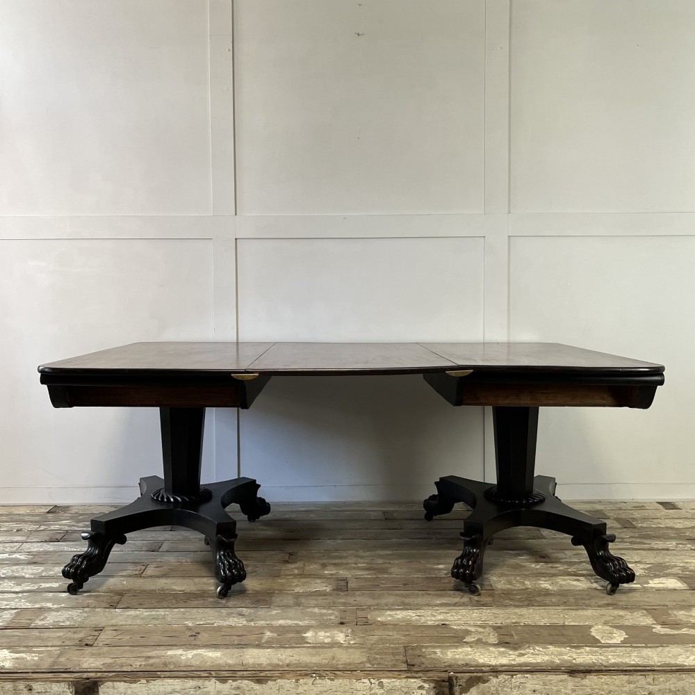A pair of William IV ebonised mahogany console tables with polished mahogany tops, central pedestal columns, and carved claw feet on brass castors. View XIII
