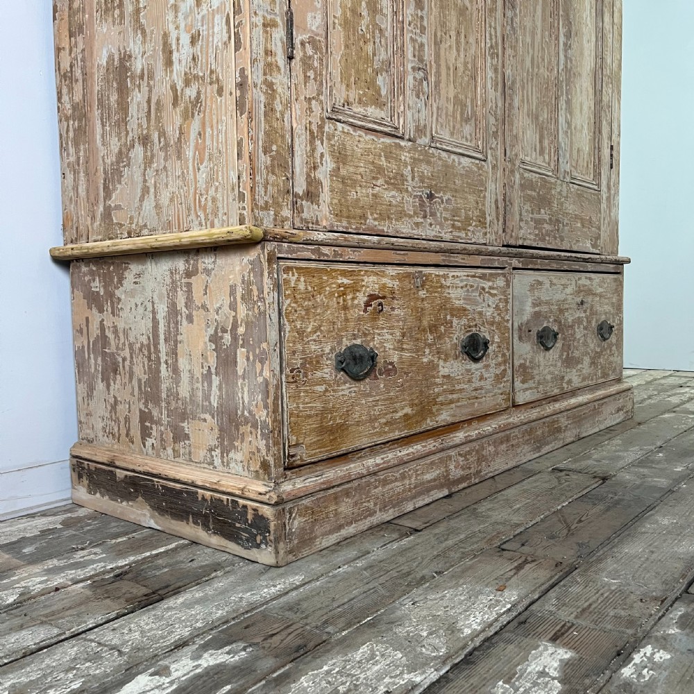 A tall Victorian pine housekeepers cupboard with distressed cream painted finish, double panelled doors, and two bottom drawers. View VI