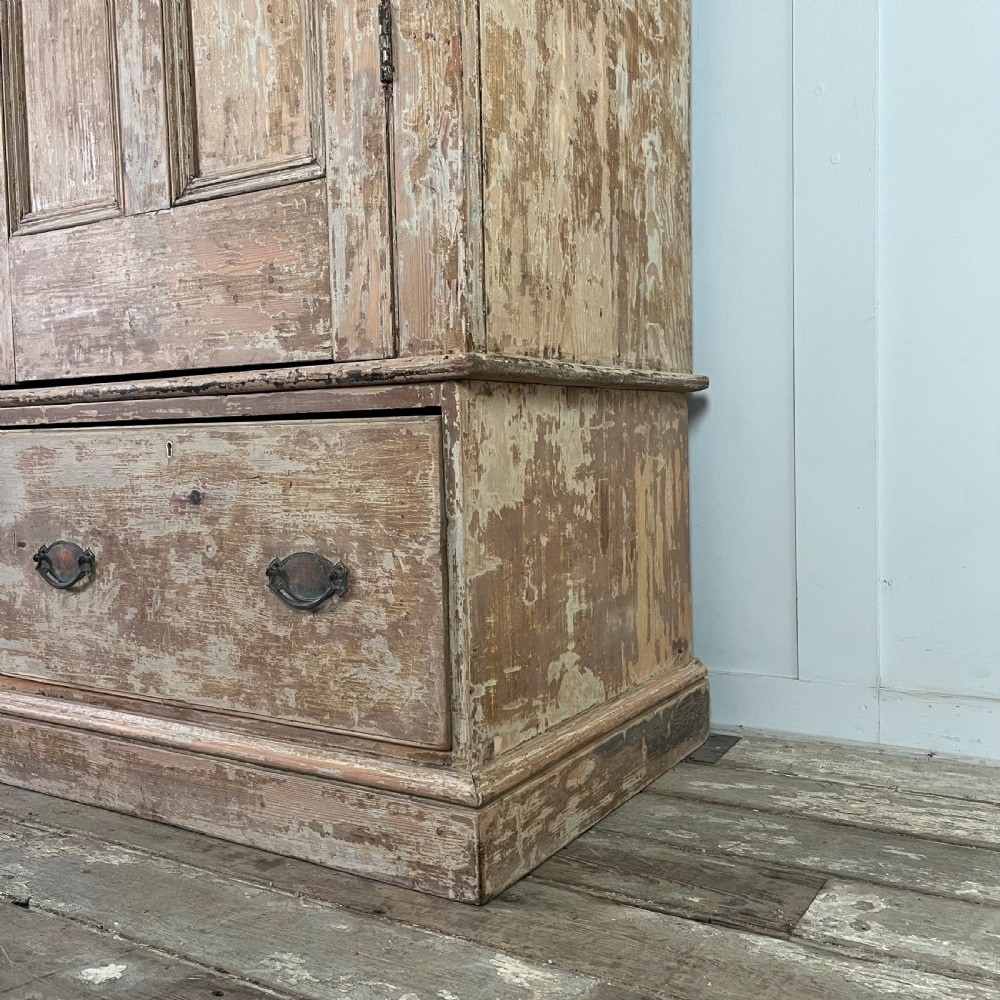 A tall Victorian pine housekeepers cupboard with distressed cream painted finish, double panelled doors, and two bottom drawers. View VII
