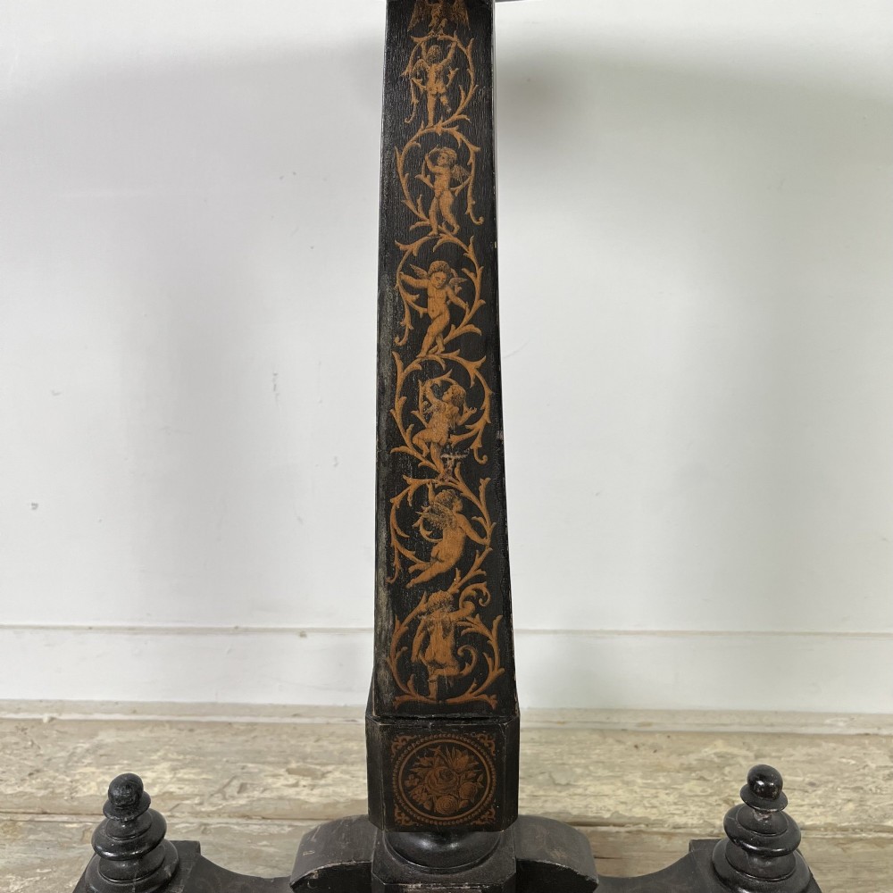 An early nineteenth-century octagonal ebonised tilt-top table featuring intricate ink-drawn classical figures and floral penwork borders. View VII